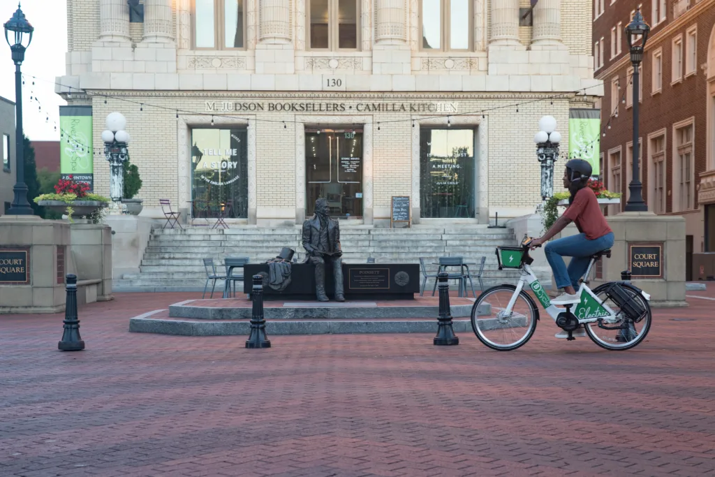 Woman riding a bike share bicycle in downtown Greenville.